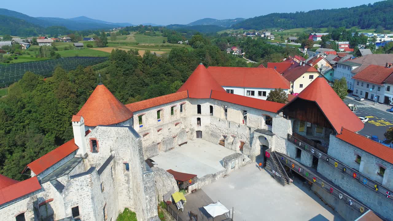 Zuzemberk Castle on top of the hill, surrounding town. Aerial reveal
