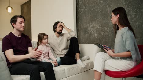 Sad-gay-couple-discussing-their-relationships-with-daughter-with-psychologist