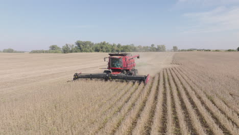 Aerial-Low-to-the-Ground-Shot-of-Combine-Harvester-Harvesting-Dry-Soybeans-on-Rural-Farm