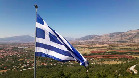 Clip-Aéreo-De-Drones-4k-De-Una-Bandera-Ondeando-Sobre-El-Monte-Korilovos-En-El-área-Del-Drama-En-El-Norte-De-Grecia