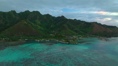 bungalows cooks opunohu bay moorea island french polynesia aerial drone morning boats passe clear skies lagoon coral reef waves mount mauaroa tohivea rotui haapiti pacific ocean backward pan up motion