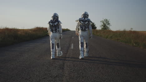 two children in astronaut suits walking down a country road.