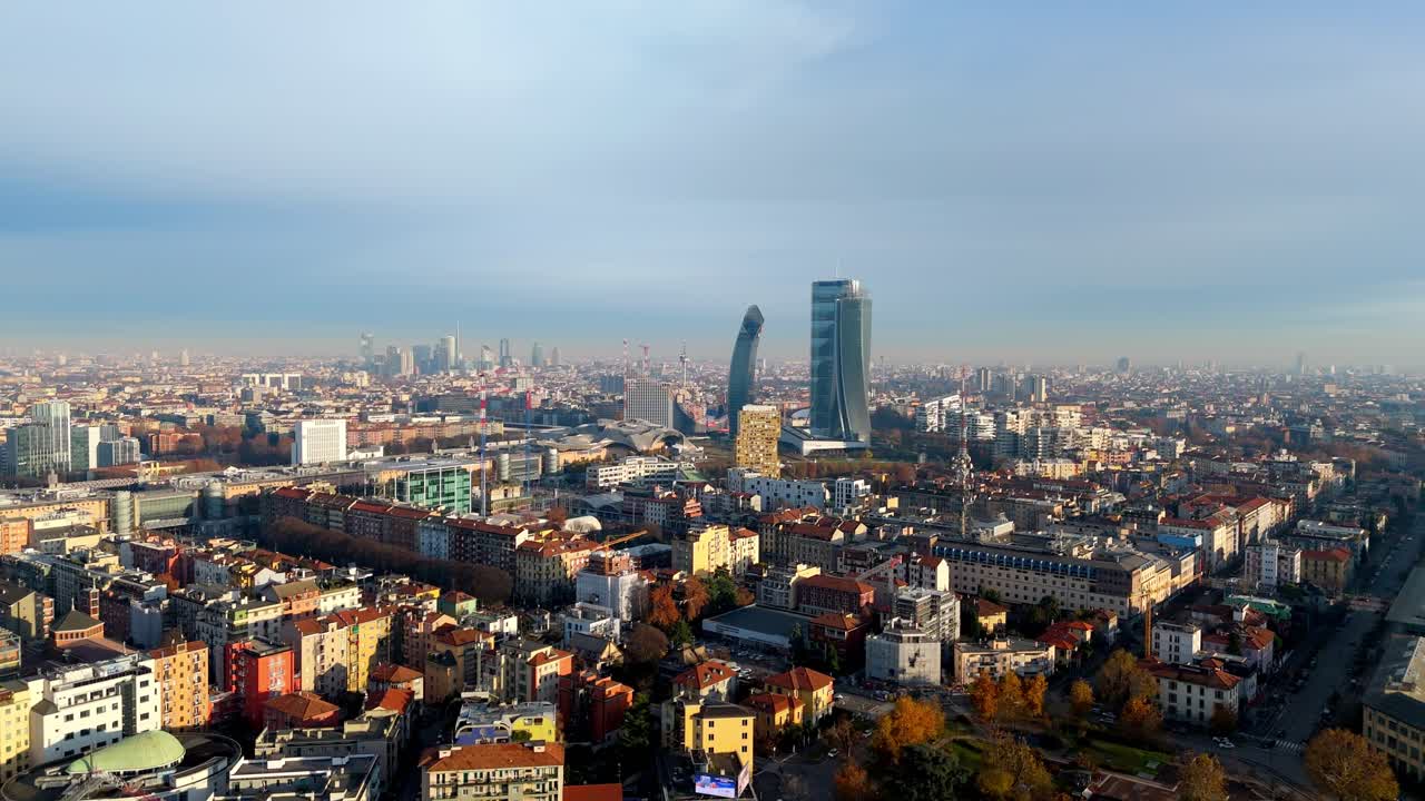 Wide aerial drone view of the modern Milan skyline, featuring the Tre Torri (CityLife) and Porta Nuova business district. Panoramic view of Italy's financial and fashion capital