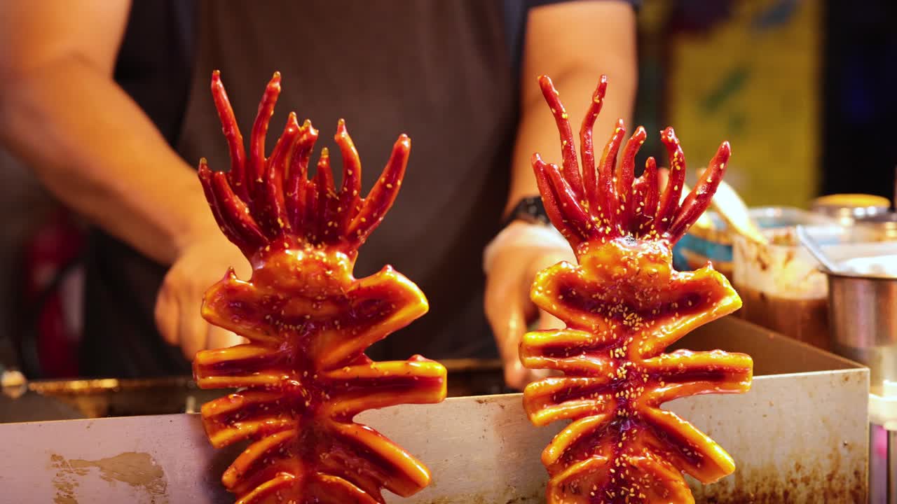 el vendedor prepara pinzones de calamar a la parrilla con especias