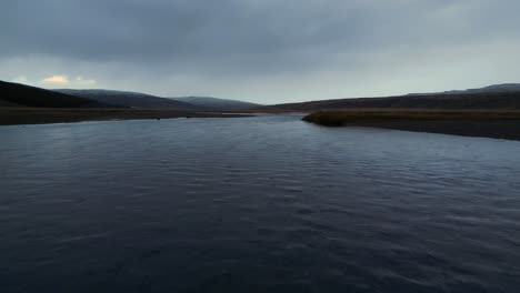 Flowing-Glacier-River-on-Gloomy,-Stormy-Iceland-Day---Aerial-Landscape