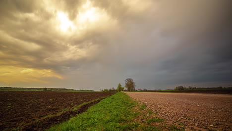 Nubes-Oscuras-De-Tormenta-Comienzan-A-Fluir-Sobre-El-Paisaje-Agrícola,-Lapso-De-Tiempo