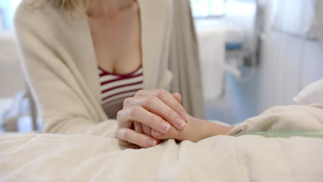 Caucasian-female-doctor-using-stethoscope-on-chest-of-girl-patient-in-face-mask-in-bed,-slow-motion