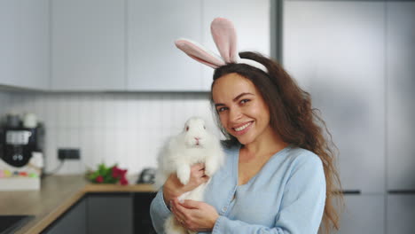 woman holding a white rabbit with bunny ears