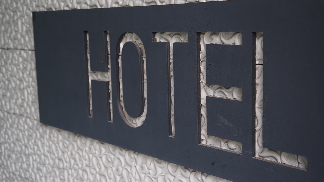 Modern Hotel Sign with Cutout Letters on a Textured Wall