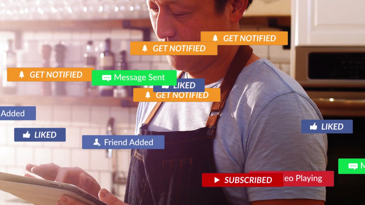 Man lifting tablet in kitchen, causing tech subscribe and like overlays flooding before fading