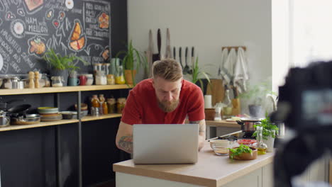 food blogger working on laptop in kitchen studio