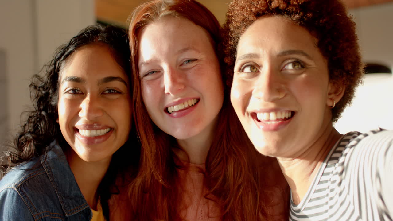 Posing and smiling, diverse female friends enjoying time together indoors