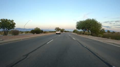 point of view - driving in near sunset in tucson on golf links road - a 6 lane expressway