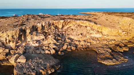 aerial - rocky coastal limestone cliff near mediterranean sea, cyprus