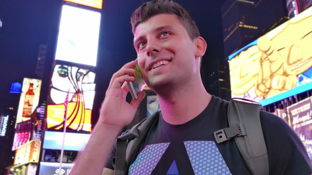 Man Talking on Phone in Times Square at Night