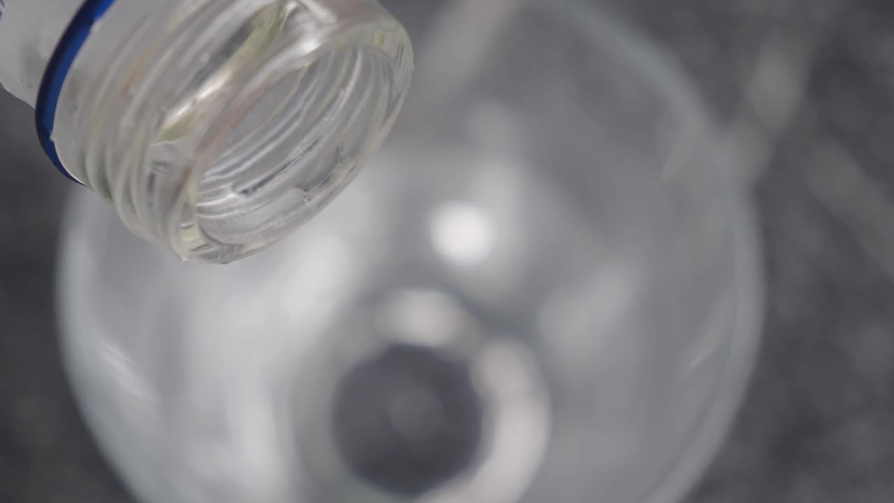 vertiendo vodka en un vaso con hielo