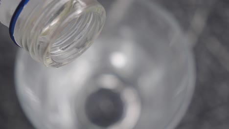 vertiendo vodka en un vaso con hielo