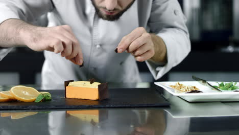 el chef poniendo chocolate en el pastel en cámara lenta. el panadero finalizando el postre.