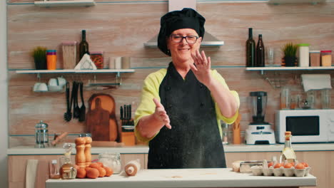 baker claps her hands with flour over the table