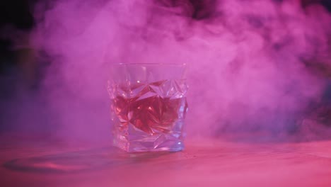 glass covered in smoke with purple-pink lights