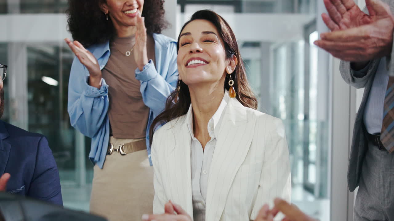 una mujer de negocios recibiendo aplausos de su equipo.
