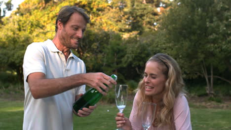 handsome man opening a bottle of champagne