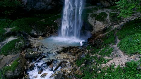 el hombre con barba está haciendo meditación de cascada bajo una gran cascada.
