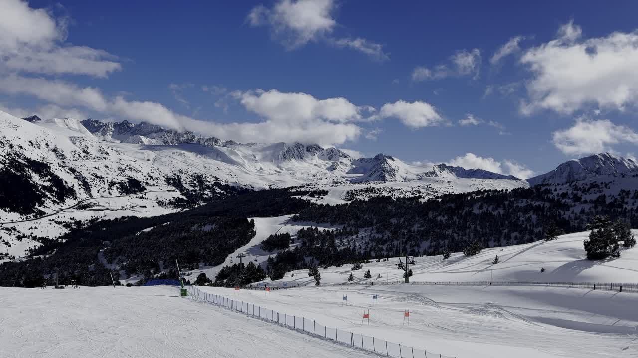 Andorra'daki Grandvalira kayak merkezi üzerinde 4K sinematik drone uçuşu, güneşli karlı yamaçları, modern telesiyejleri ve görkemli Pireneler sıradağlarını gösteriyor.