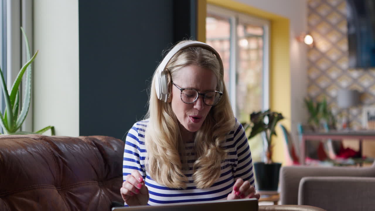 Woman on video call with laptop and headphones