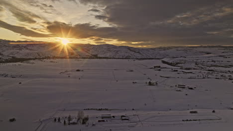 Oakley-Utah-Aerial-v1-drone-flyover-village-town-capturing-golden-sunset-sun-shinning-across-pristine-snow-fields-and-beautiful-mountainous-landscape-in-winter---Shot-with-Mavic-3-Cine---February-2023
