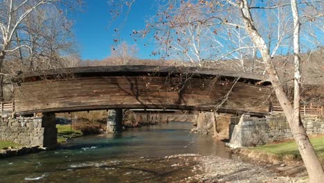 Swift-clear-water-runs-under-a-covered-bridge-in-the-mountains