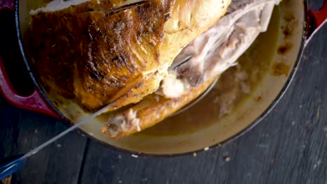 tallado de pavo entero al horno con hierbas con vista superior de cuchillo eléctrico