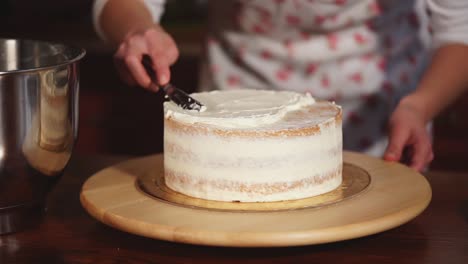 woman decorating a layered cake