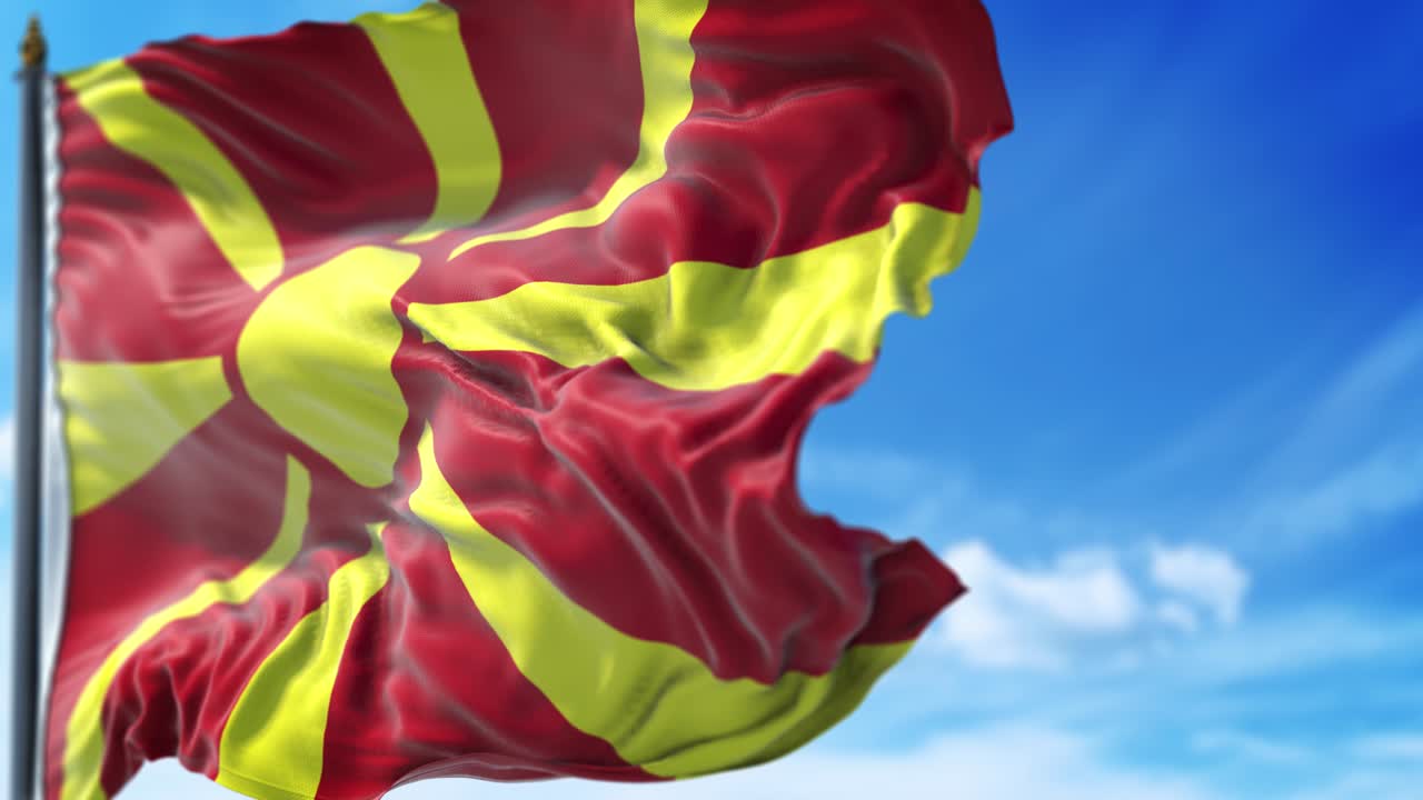 la bandera macedonia está ondeando lentamente contra el cielo azul