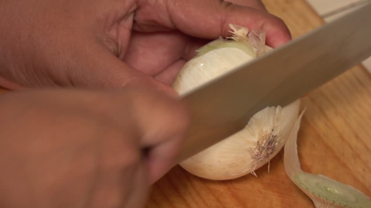 A yellow onion peeled and diced on a cutting board