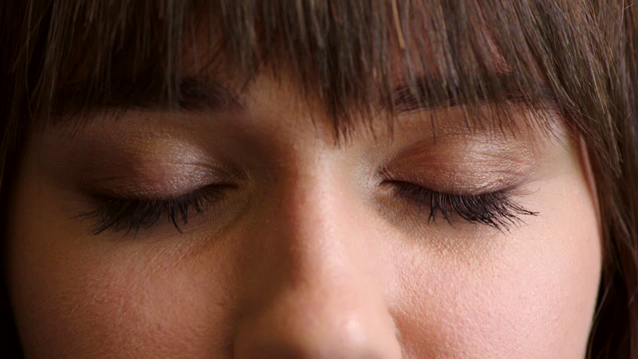 어두운 스튜디오에서 파란 눈을 가진 여성의 클로즈업