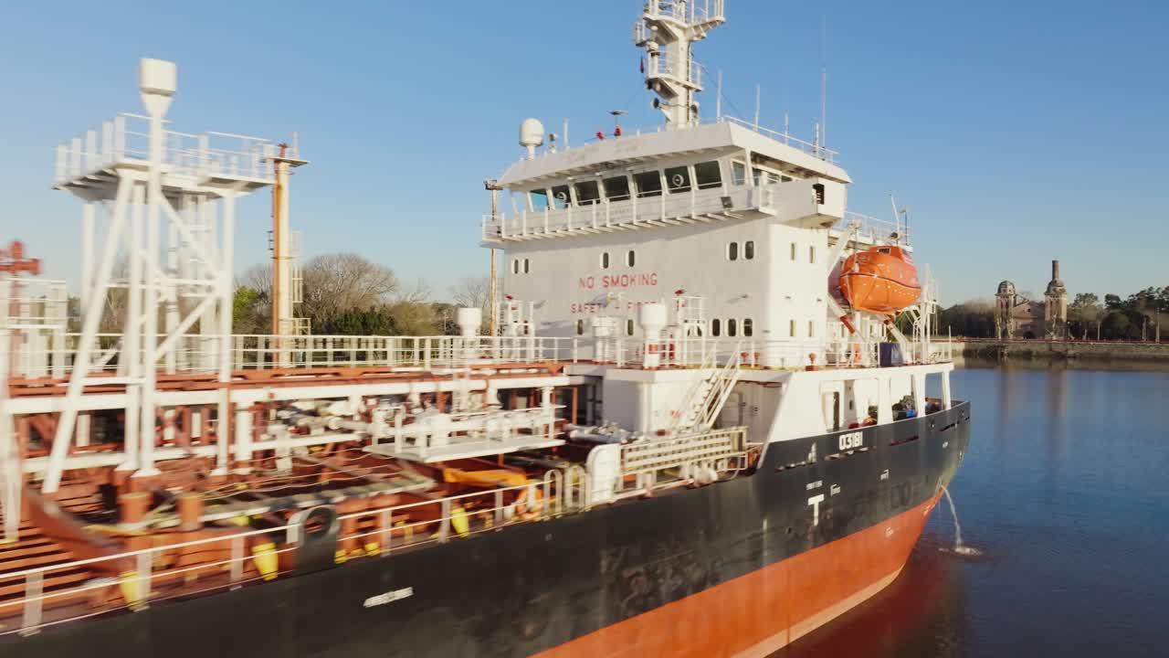 Cargo vessels docked with cranes loading containers on Río de la Plata, Argentina, drone daytime footage
