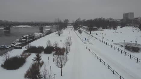 Drohnenvideo-Eines-Verschneiten,-Schneebedeckten-Flussufers-In-Warschau,-Polen