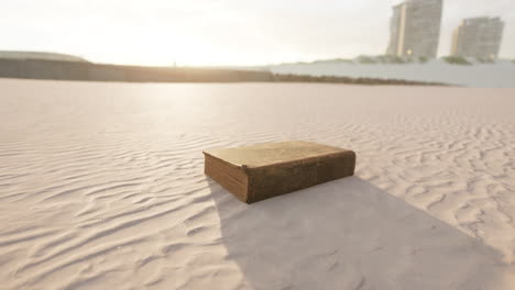 old book on a deserted beach at sunset