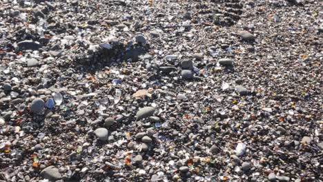 gimbal close-up panning shot of glass fragments amongst the sand at glass beach in fort bragg, california. 4k