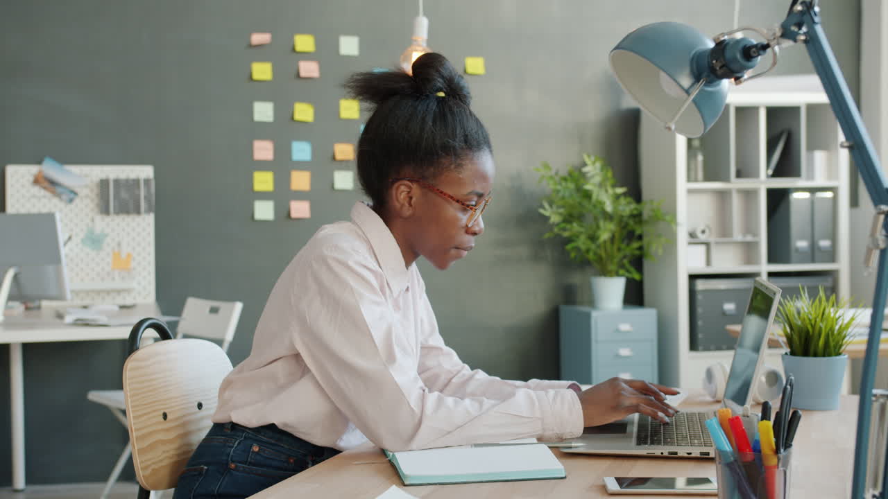 Young Woman Working on Laptop in Modern Office