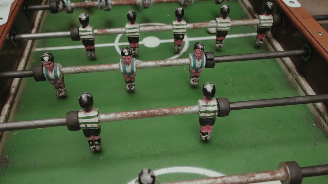 활기 넘치는 경기에서 선수들이 경쟁하는 푸스볼 테이블의 클로즈업 뷰