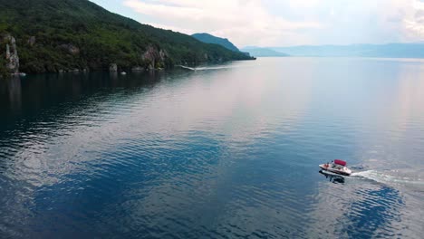 aerial shot of macedonia coast and boat entering a bay