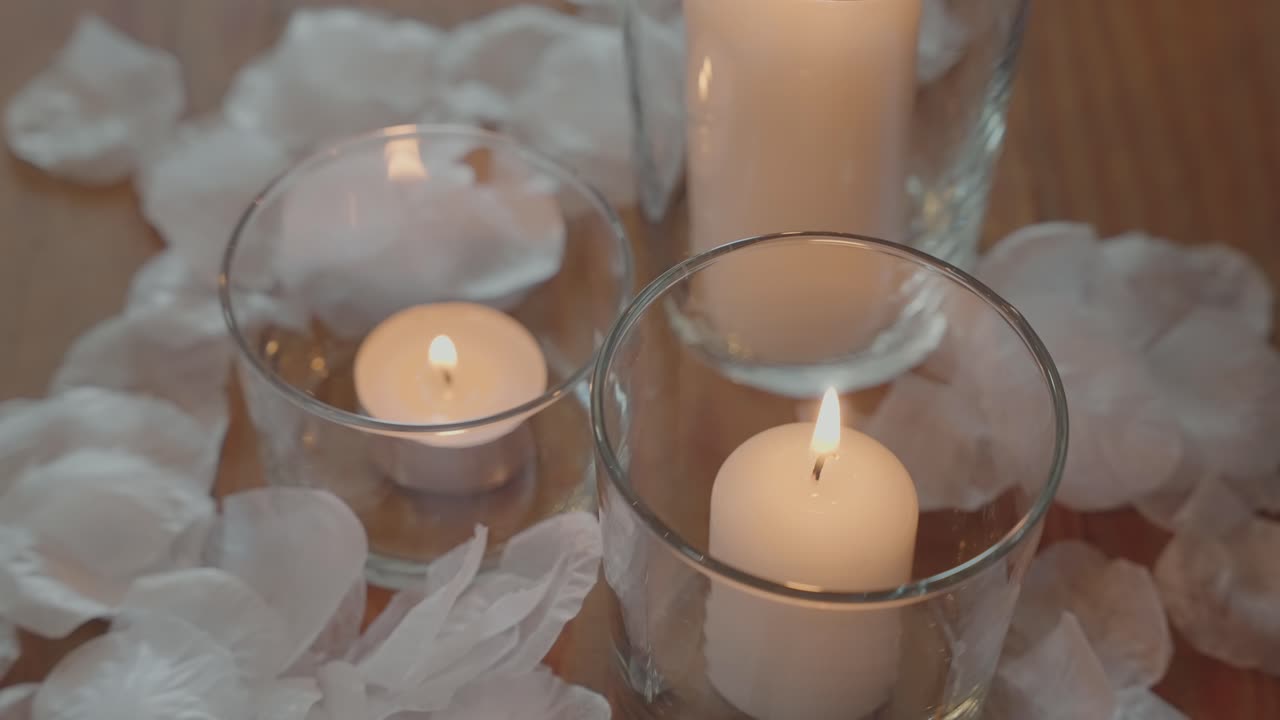 Soft glowing candles surrounded by delicate white petals creating a romantic mood