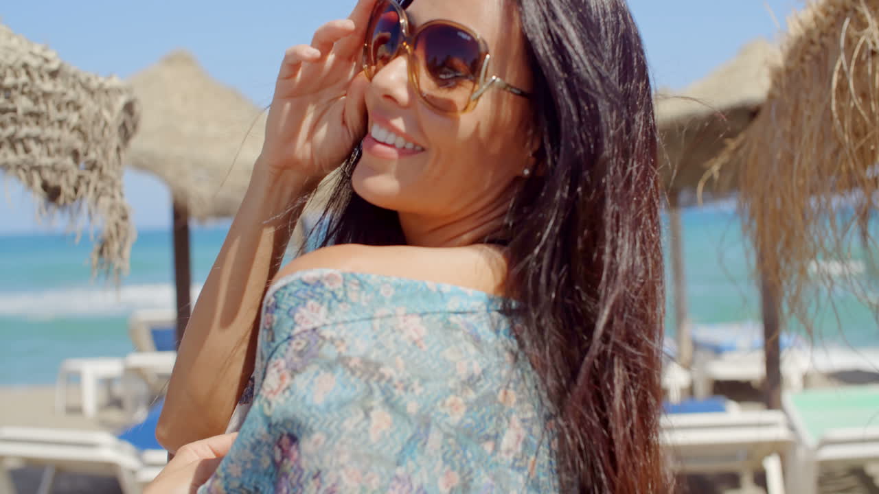 joven alegre en la playa mirando a la cámara