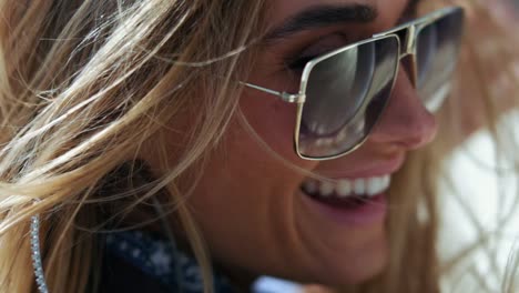 primer plano, tiro, de, mujer rubia, en, gafas de sol, reír