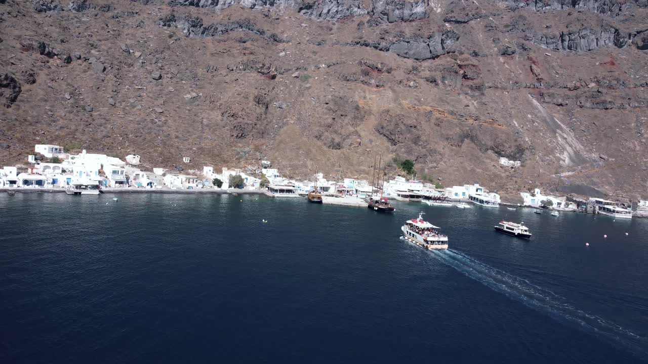 drone siguiendo un pequeño bote hasta el puerto de thirasia, santorini, grecia