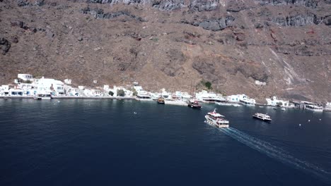 drone following a small boat to the port of thirasia, santorini, greece