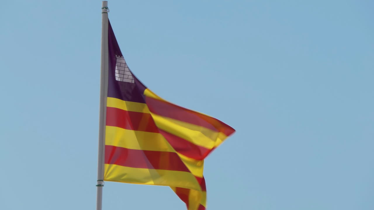 bandera de tela real de las islas baleares una comunidad autónoma en españa, ondeando en el viento contra un cielo azul
