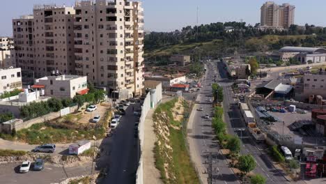 aerial view of a concrete separation wall dividing an urban area with buildings and a road